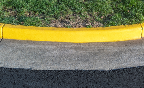 closeup of a yellow cleanly-painted curb